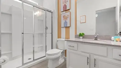 a bathroom with a shower and a toilet and a sink at Upstay Family Home w Pool, Cinema & Games Room in Kissimmee