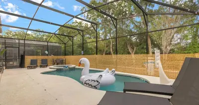 a swimming pool with two swans in the water at Upstay Family Home w Pool, Cinema & Games Room in Kissimmee