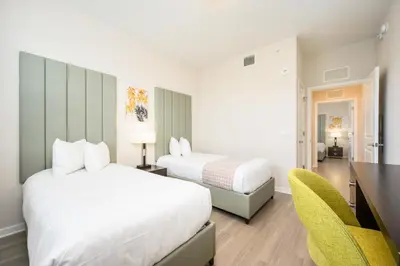 a bedroom with two beds and a desk and a chair at Brand New Modern Vista Cay Reserve Condo - 5008 in Orlando