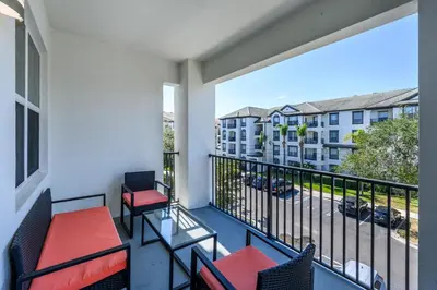 a balcony with two chairs and a view of a street at Brand New Modern Vista Cay Reserve Condo - 5008 in Orlando