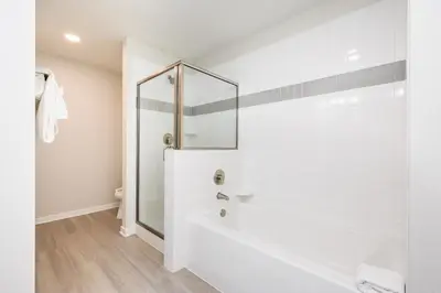 a white bathroom with a shower and a tub at Brand New Modern Vista Cay Reserve Condo - 5008 in Orlando