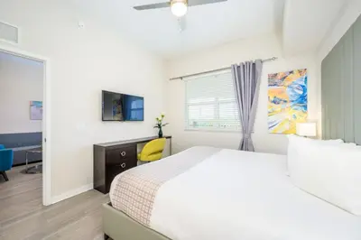 a white bedroom with a bed and a window at Epic Universe Modern Vista Cay Condo - 5005 in Orlando
