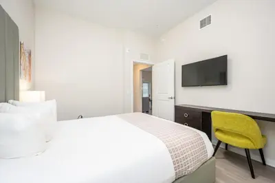 a bedroom with a bed and a desk with a television at New Modern Vista Cay Reserve Condo - 5006 in Orlando