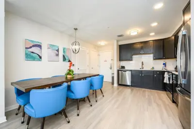 a kitchen with a wooden table and blue chairs at New Modern Vista Cay Reserve Condo - 6003 in Orlando