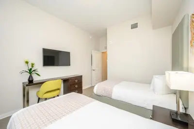 a bedroom with two beds and a desk with a yellow chair at Epic Universe New Modern Vista Cay Reserve Condo - 5007 in Orlando