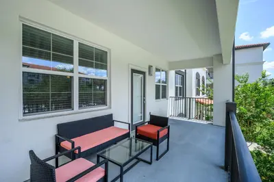 a balcony with two chairs and a bench on it at Epic Universe Brand New Modern Vista Cay Reserve Condo - 6005 in Orlando
