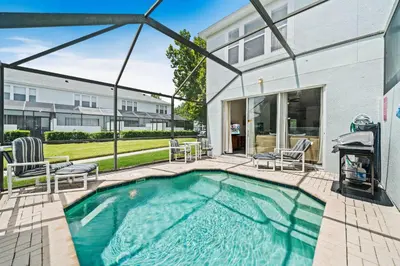 a swimming pool with patio furniture and a house at 2533 Renshaw Street in Orlando