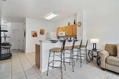 a living room with a kitchen with a counter and stools at 2533 Renshaw Street in Orlando