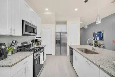 a white kitchen with a sink and a stove at 3BD 3BA Themed House Near Disney in Orlando