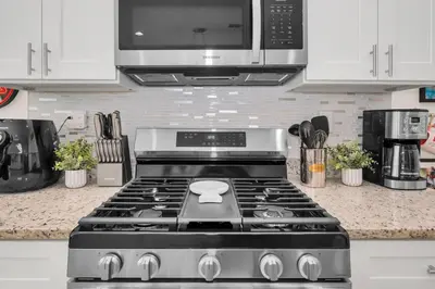 a kitchen with a stove and a microwave at 3BD 3BA Themed House Near Disney in Orlando