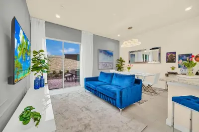 a living room with a blue couch and a table at 3BD 3BA Themed House Near Disney in Orlando