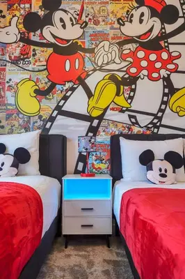 a bedroom with two beds and a mural of mickeys at 5 BD 5BA Themed House Near Disney in Orlando