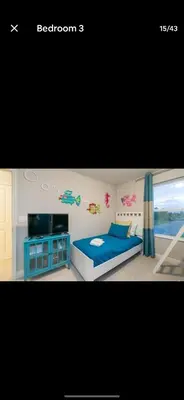 a bedroom with a blue bed and a tv at Pool Private tub BBQ Mins to Disney and Universal in Kissimmee