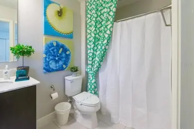 a bathroom with a toilet and a shower curtain at Pool Private tub BBQ Mins to Disney and Universal in Kissimmee