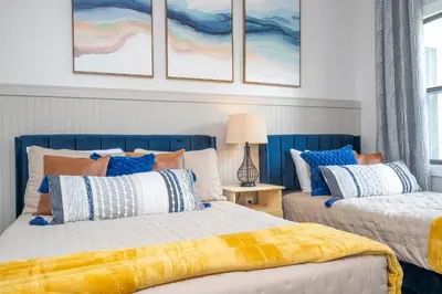 two beds in a bedroom with blue and white at Cozy apt 2 bedrooms 1 mile Universal Studios in Orlando