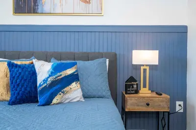 a blue bedroom with a bed with a nightstand with a lamp at Cozy apt 2 bedrooms 1 mile Universal Studios in Orlando