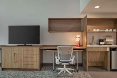 an office with a desk with a tv and a chair at Home2 Suites By Hilton Sanford Orlando North in Sanford