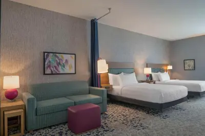 a hotel room with a bed and a couch and a bed and a chair at Home2 Suites By Hilton Sanford Orlando North in Sanford