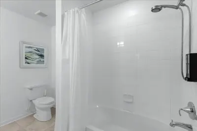 a white bathroom with a shower and a toilet at 2 Bedrooms 2 Bathrooms Storey Lake Ct in Kissimmee