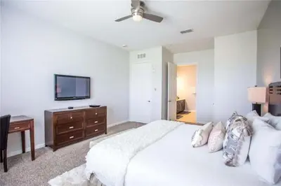 a bedroom with a white bed and a television at The Epic Boca Penthouse Vista Cay Orlando in Orlando