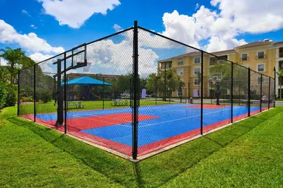 a tennis court with a net in a park at The Epic Boca Penthouse Vista Cay Orlando in Orlando