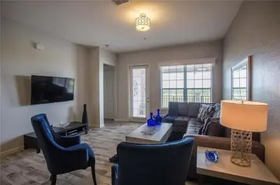 a living room with a couch and a table and chairs at The Epic Boca Penthouse Vista Cay Orlando in Orlando