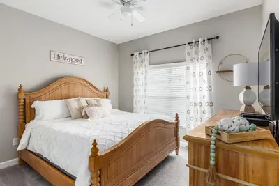 a bedroom with a wooden bed and a window at Palms of Paradise! in Kissimmee