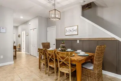 a dining room with a wooden table and chairs at Palms of Paradise! in Kissimmee