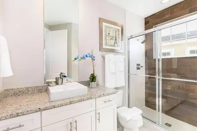 a white bathroom with a sink and a shower at Cozy Beautiful 5 Suites close to Disney World in Orlando