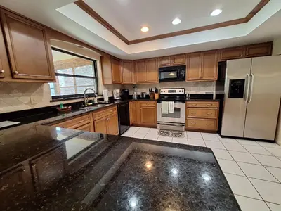 a kitchen with wooden cabinets and stainless steel appliances at 3 Bed 2 Bath amazing Lakeview , Jacuzzi Bath Tub in Oviedo