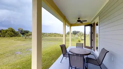 a porch with a table and chairs and a fan at Quiet 2 Bed Cottage in Oviedo w Resort Discounts in Oviedo