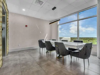 a dining room with a table and chairs and a large window at Lovely 2Bdrm 2Bath Thorton Park Condo with secure parking in Orlando