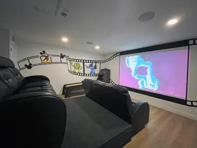 a room with two black leather chairs and a large screen at Stardust Villa home in Kissimmee