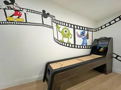 a bedroom with a bed with mickey mouse and a wall at Stardust Villa home in Kissimmee