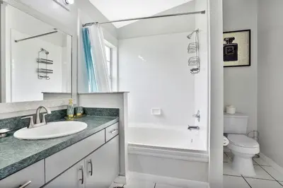 a white bathroom with a sink and a toilet at Stunning Home Near Disney World in Orlando