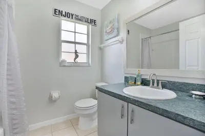 a bathroom with a sink and a toilet and a mirror at Stunning Home Near Disney World in Orlando