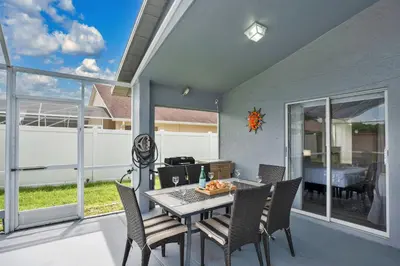 a dining room with a table and chairs on a patio at Stunning Home Near Disney World in Orlando