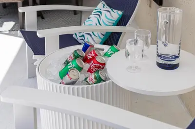 a white table with a basket of soda cans at Beautiful home, centrally located to Parks with Pool in Orlando