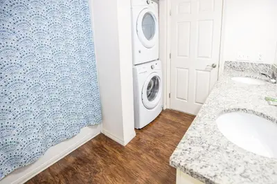 a bathroom with a washer and dryer next to a washing machine at Elegant, Spacious 3bedroom Near Attractions Hot Tub Pool & Gym in Kissimmee