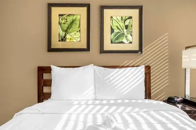 a bedroom with a bed with two pictures on the wall at Enchanted 4BR Family Style Townhome in Disney Area in Orlando