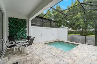 a swimming pool in a house with a table and chairs at Amazing 4 Bedrooms Next to DisneyPrivate Pool in Orlando