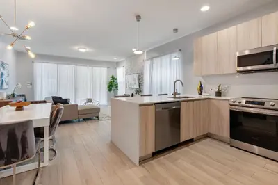 a kitchen and living room with a table and a sink at Amazing 4 Bedrooms Next to DisneyPrivate Pool in Orlando