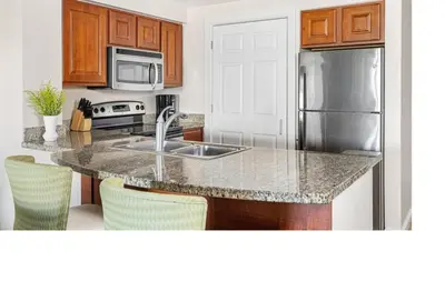 a kitchen with a sink and a stainless steel refrigerator at Marriott Grande Vista Luxury 1BD villa sleeps 4 in Orlando