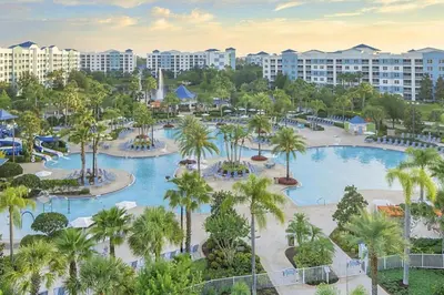 an aerial view of a resort pool with palm trees at Enjoy your AM coffee in resort relaxation garden in this great 1BD condo in Orlando in Orlando