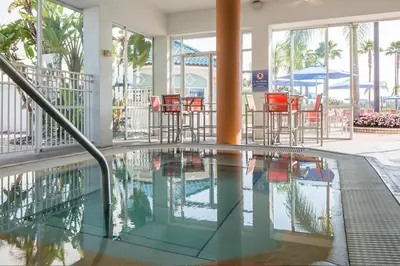 a swimming pool with chairs and tables in a building at Enjoy your AM coffee in resort relaxation garden in this great 1BD condo in Orlando in Orlando