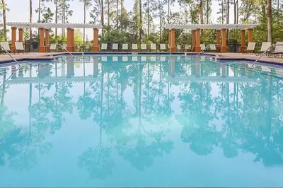 a swimming pool with blue water and two benches at Take the Family to Orlando in this great 2BD in a resort setting with tons of amenities in Orlando