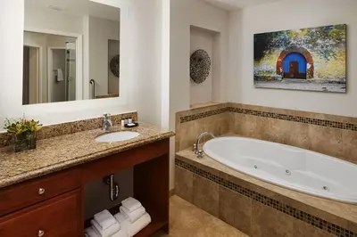 a bathroom with a tub and a sink and a mirror at Family fun in this 2BD condo with multiple pools, mini golf, restaurants etc onsite in Orlando