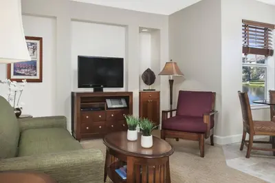 a living room with a couch and a tv at Family fun in this 2BD condo with multiple pools, mini golf, restaurants etc onsite in Orlando