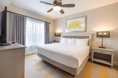a bedroom with a white bed and a ceiling fan at WorldMark Kingstown Reef - 2BD Sleeps up to 6 in Orlando