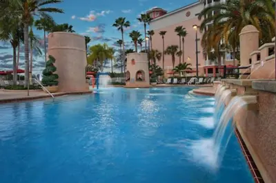 a pool at a resort with blue water and palm trees at Marriott Grande Vista 2BD villa sleeps 8 in Orlando